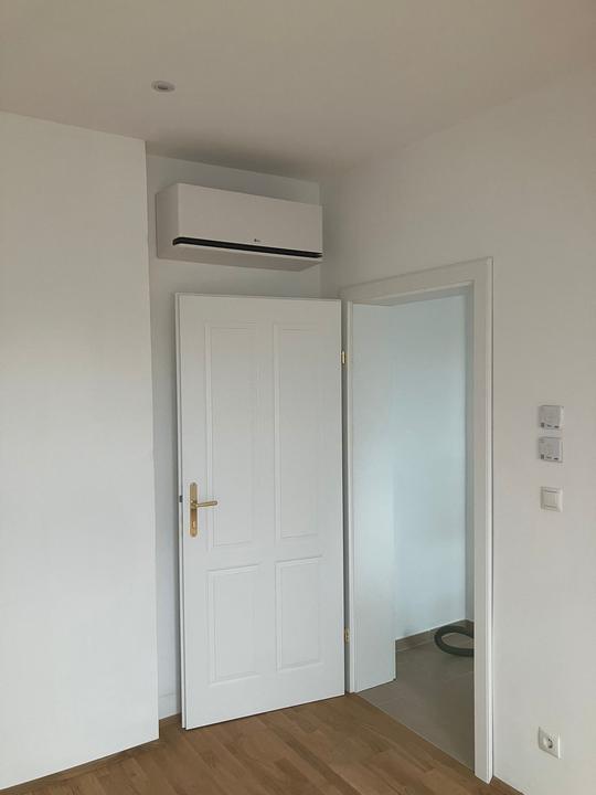 LG Wandgerät über einer weißen Kassettentür