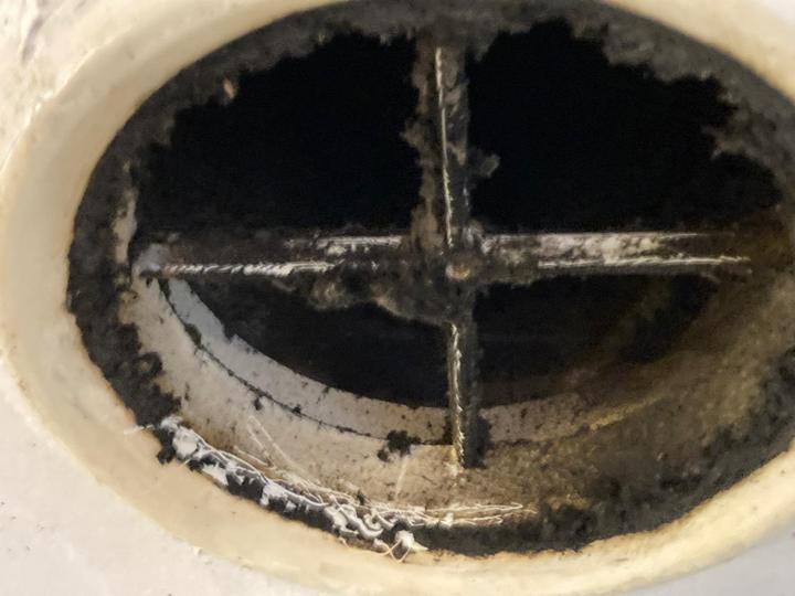 Blick in den Luftauslass: schwarze Ablagerungen am Einbauring und am Haltekreuz